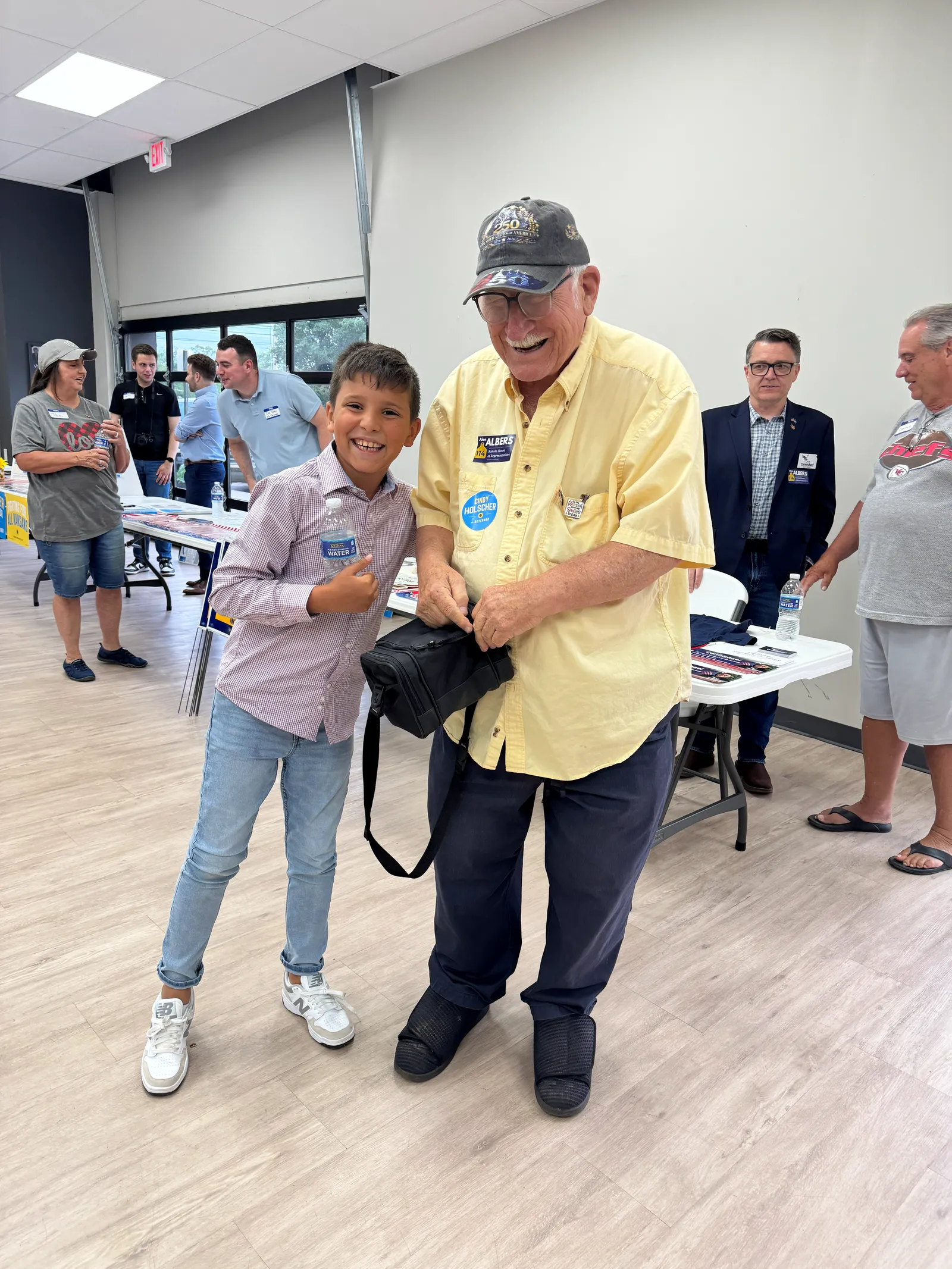 A young supporter shares a laugh with an attendee at the Kingman County event.