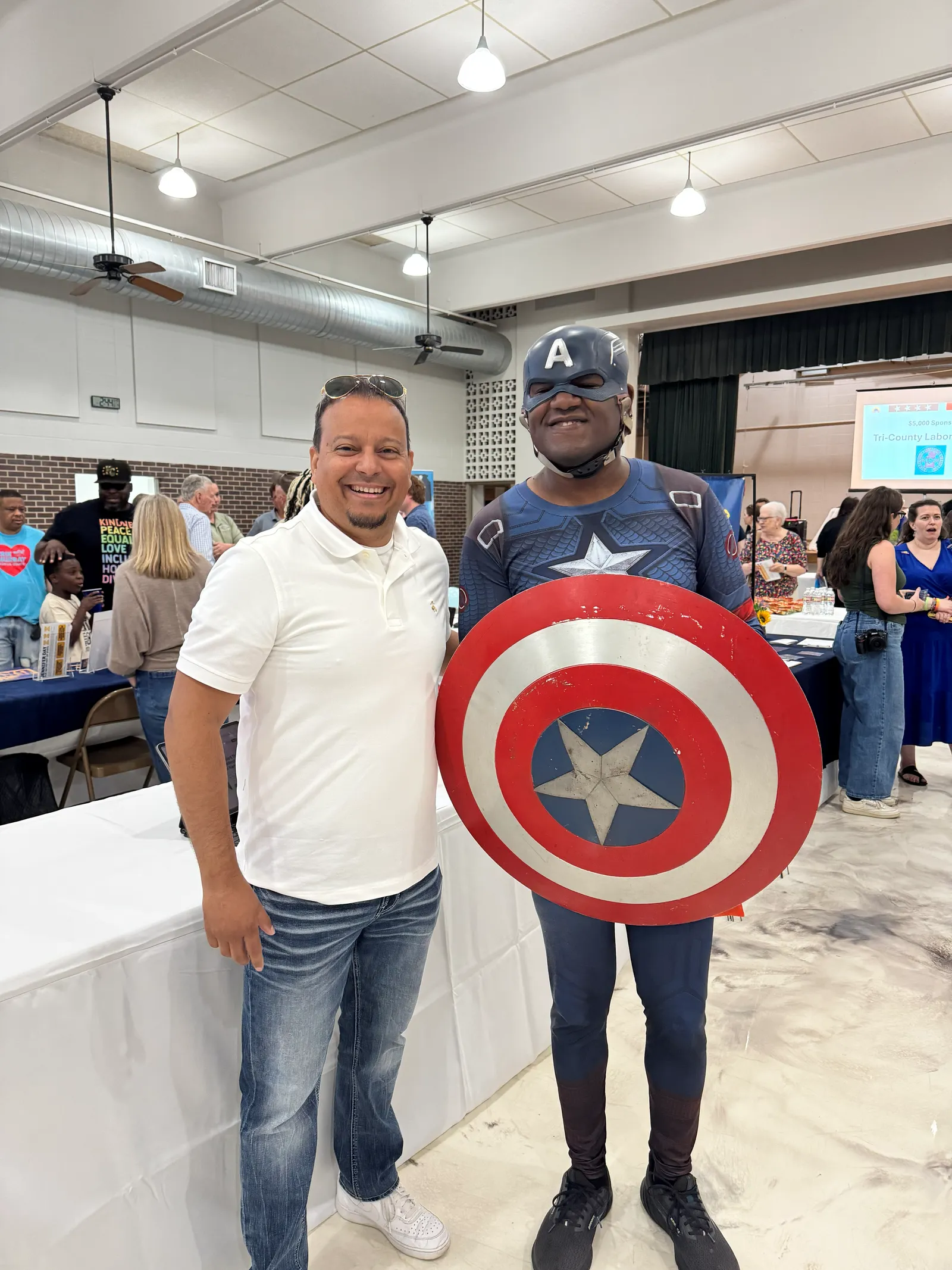 Juan C. Luengo stands with a young supporter dressed as Captain America at a Wyandotte County campaign event.